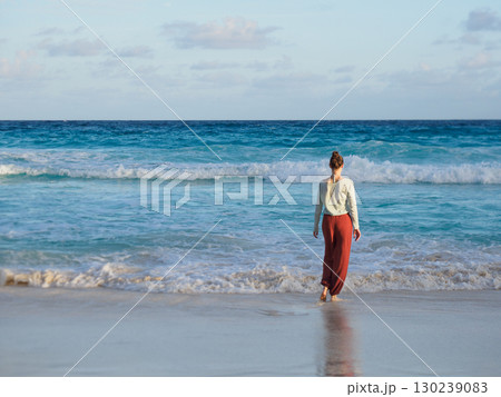 Cute woman walking on stunning white sand beach Cute woman walking on stunning white sand beach 130239083