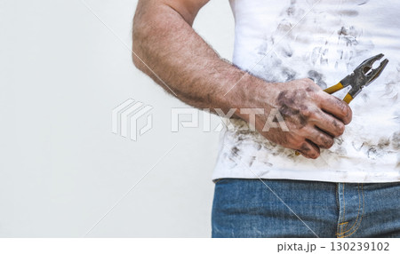Handsome worker, pliers and dirty t-shirt 130239102