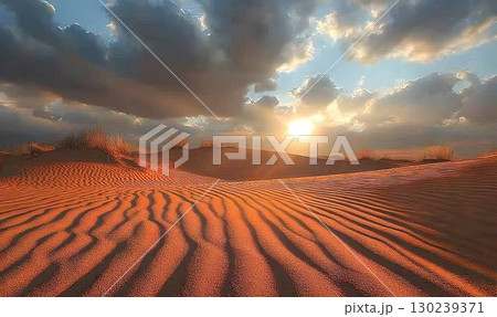 Dramatic Sunset Over Desert Dunes with Striking Light and Shadow 130239371