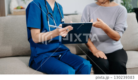 Doctors explain the use of medication to patients. Medical doctor holing senior patient's hands and comforting her on sofa Doctors explain the use of medication to patients. Medical doctor holing senior patient's hands and comforting her on sofa 130239383