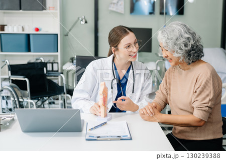 Doctor in white suit take notes while discussing and Asian elderly, man patient who lying on bed with receiving saline solution Doctor in white suit take notes while discussing and Asian elderly, man patient who lying on bed with receiving saline solution 130239388