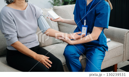 Doctors explain the use of medication to patients. Medical doctor holing senior patient's hands and comforting her on sofa 130239531