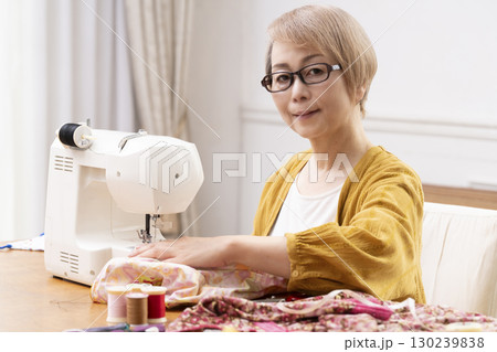 ミシンで洋服や小物を楽しそうに縫うシニア女性 130239838