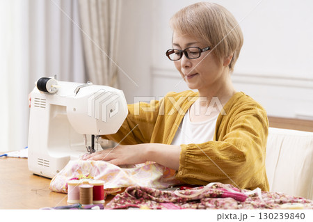 ミシンで洋服や小物を楽しそうに縫うシニア女性 ミシンで洋服や小物を楽しそうに縫うシニア女性 130239840