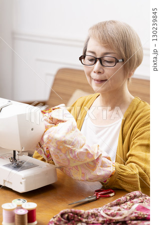 ミシンで洋服や小物を楽しそうに縫うシニア女性 ミシンで洋服や小物を楽しそうに縫うシニア女性 130239845