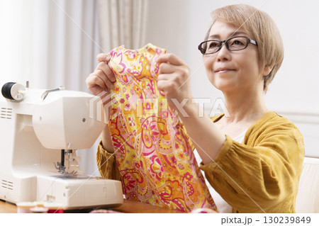 ミシンで洋服や小物を楽しそうに縫うシニア女性 ミシンで洋服や小物を楽しそうに縫うシニア女性 130239849