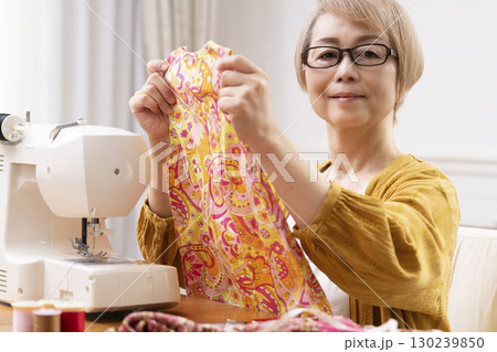 ミシンで洋服や小物を楽しそうに縫うシニア女性 ミシンで洋服や小物を楽しそうに縫うシニア女性 130239850