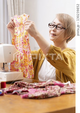 ミシンで洋服や小物を楽しそうに縫うシニア女性 ミシンで洋服や小物を楽しそうに縫うシニア女性 130239852