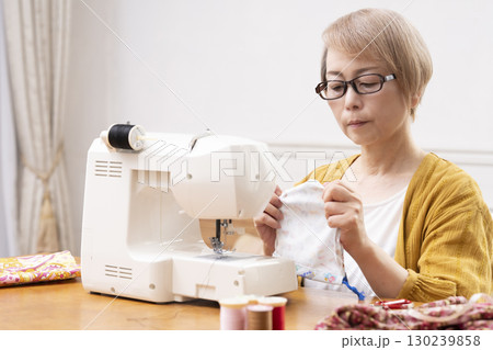 ミシンで洋服や小物を楽しそうに縫うシニア女性 ミシンで洋服や小物を楽しそうに縫うシニア女性 130239858