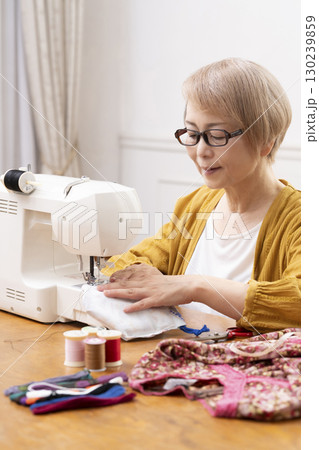 ミシンで洋服や小物を楽しそうに縫うシニア女性 ミシンで洋服や小物を楽しそうに縫うシニア女性 130239859