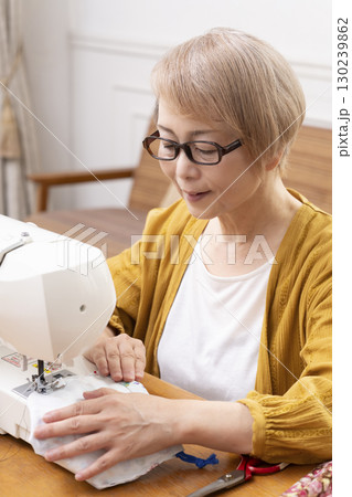 ミシンで洋服や小物を楽しそうに縫うシニア女性 ミシンで洋服や小物を楽しそうに縫うシニア女性 130239862
