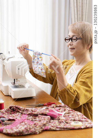 ミシンで洋服や小物を楽しそうに縫うシニア女性 ミシンで洋服や小物を楽しそうに縫うシニア女性 130239863