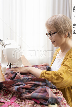 ミシンで洋服や小物を楽しそうに縫うシニア女性 ミシンで洋服や小物を楽しそうに縫うシニア女性 130239872