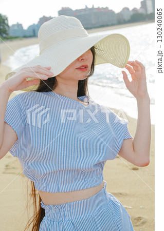 夏の百道浜を歩く若い女性 130240065
