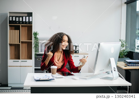 Confident female entrepreneur looking at the camera while standing. Young businesswoman standing 130240341