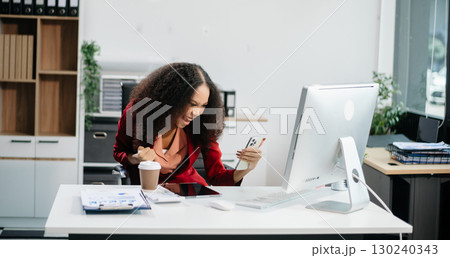 Confident female entrepreneur looking at the camera while standing. Young businesswoman standing Confident female entrepreneur looking at the camera while standing. Young businesswoman standing 130240343