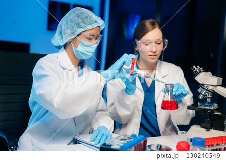 Modern Medical Research Laboratory Portrait of Two Scientists Working, Using Digital Tablet, Analyzing Samples, Talking. Modern Medical Research Laboratory Portrait of Two Scientists Working, Using Digital Tablet, Analyzing Samples, Talking. 130240549