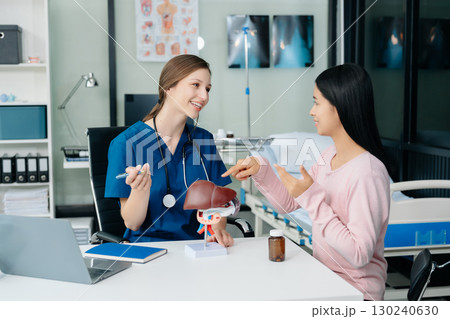Doctor discussing treatment with Female patient talks to discuss results or symptoms and sitting on examination desk 130240630