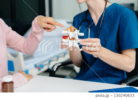 Doctor discussing treatment with Female patient talks to discuss results or symptoms and sitting on examination desk Doctor discussing treatment with Female patient talks to discuss results or symptoms and sitting on examination desk 130240633