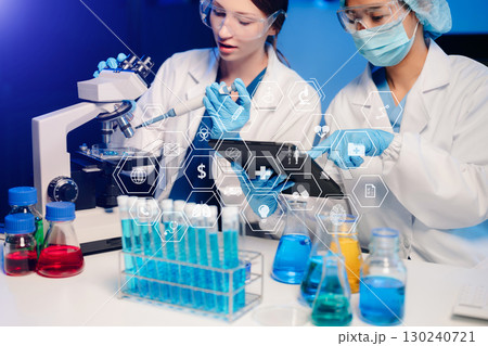 Young scientists conducting research investigations in a medical laboratory, a researcher in the foreground is using a microscope in laboratory 130240721
