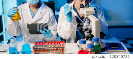 Modern Medical Research Laboratory Portrait of Two Scientists Working, Using Digital Tablet, Analyzing Samples, Talking. Modern Medical Research Laboratory Portrait of Two Scientists Working, Using Digital Tablet, Analyzing Samples, Talking. 130240725