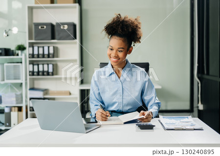 Confident business expert attractive smiling young woman typing laptop and holding digital tablet 130240895