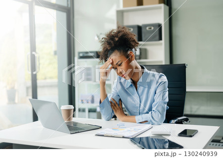 Woman feeling migraine head strain.Overworked businesswoman financier while working on laptop and tablet Woman feeling migraine head strain.Overworked businesswoman financier while working on laptop and tablet 130240939