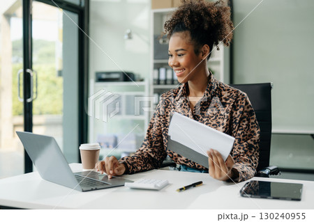 Confident business expert attractive smiling young woman typing laptop and holding digital tablet 130240955
