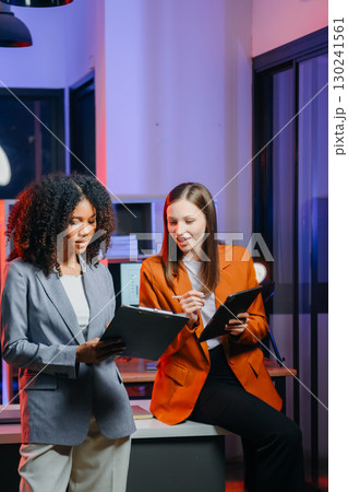 Two business workers talking on the smartphone and using laptop 130241561