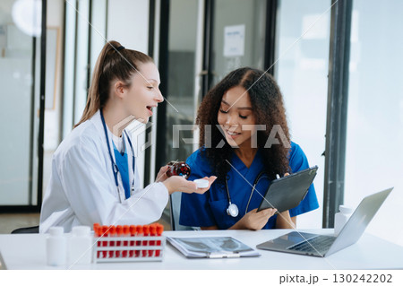 Doctor Talks With Professional Head Nurse or Surgeon, They Use Digital tablet Computer. Diverse Team of Health Care Specialists Discussing Test Result Doctor Talks With Professional Head Nurse or Surgeon, They Use Digital tablet Computer. Diverse Team of Health Care Specialists Discussing Test Result 130242202