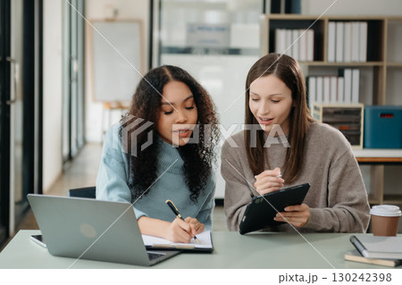 Asian business colleague business presents and explains and using laptop and tablet. Teamwork, financial marketing team Asian business colleague business presents and explains and using laptop and tablet. Teamwork, financial marketing team 130242398