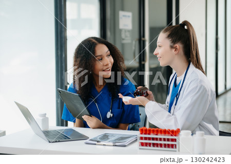 Doctor Talks With Professional Head Nurse or Surgeon, They Use Digital tablet Computer. Diverse Team of Health Care Specialists Discussing Test Result Doctor Talks With Professional Head Nurse or Surgeon, They Use Digital tablet Computer. Diverse Team of Health Care Specialists Discussing Test Result 130242423