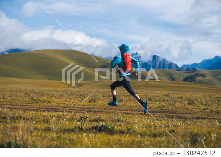 Fitness woman trail runner running in grassland 130242512