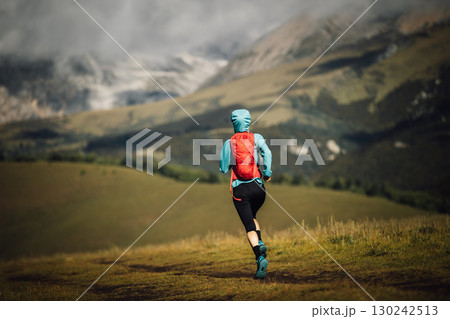 Fitness woman trail runner running in grassland 130242513
