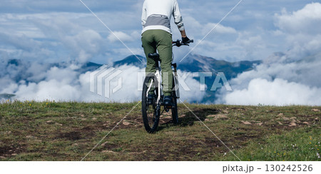 Asian woman riding a mountain bike down hill on beautiful mountain top 130242526