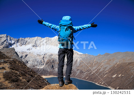 Backpacking woman hiking on high altitude mountain top 130242531