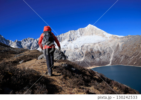 Backpacking woman hiking on high altitude mountain top Backpacking woman hiking on high altitude mountain top 130242533