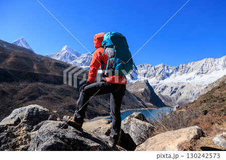 Backpacking woman checking the elevation on sports watch on high altitude mountain top 130242573