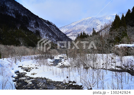 雪の残る山と川 130242924