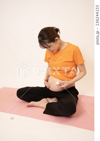 妊娠8ヶ月のお腹にクリームを塗る女性 妊娠8ヶ月のお腹にクリームを塗る女性 130244155