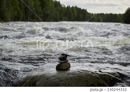 A Beautiful Serene River Landscape Featuring a Collection of Balancing Stones Artistically Arranged 130244332