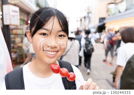 鎌倉観光をしながら食べ歩きをする10代の女性 130244333