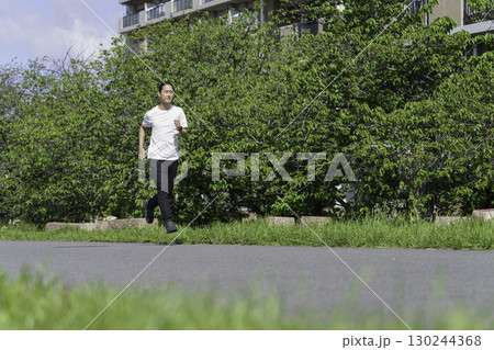 多摩川の土手をランニングする若い男性 多摩川の土手をランニングする若い男性 130244368