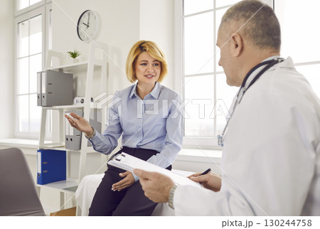Female mature patient visiting a doctor at the medical office during medical examination. Female mature patient visiting a doctor at the medical office during medical examination. 130244758