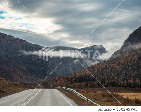 Road Leading to Mountains with Fog in Altai, Russia Road Leading to Mountains with Fog in Altai, Russia 130245745