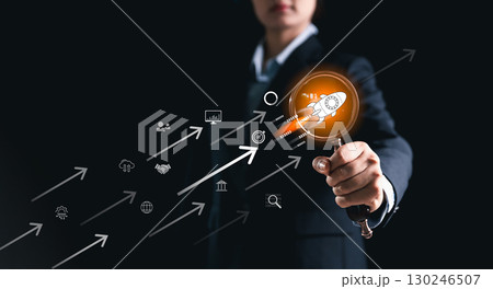 Businesswoman pointing at startup rocket icon with digital arrows, symbolizing innovation, growth, technology, entrepreneurship, success, leadership and future business development. Businesswoman pointing at startup rocket icon with digital arrows, symbolizing innovation, growth, technology, entrepreneurship, success, leadership and future business development. 130246507