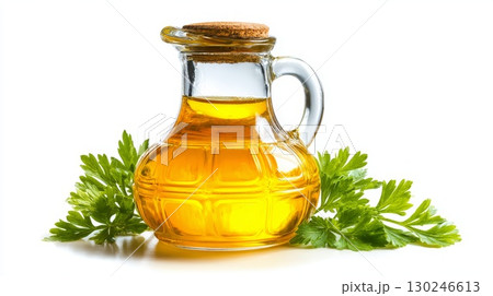 Glass jug of golden oil with fresh vegetables and peppercorns 130246613