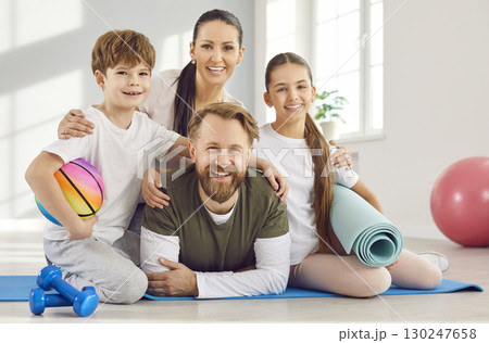 Portrait of happy parents and children during a family fitness workout at the gym 130247658