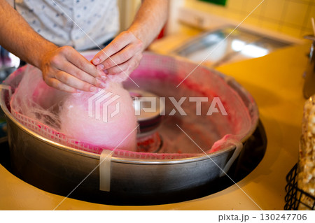 Male adult making pink cotton candy at a carnival stand Male adult making pink cotton candy at a carnival stand 130247706