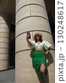 Beautiful tourist girl with hat holding smartphone and talking at the city square. 130248617